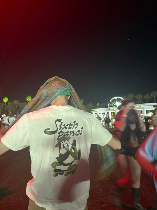 Men’s ivory Trombone Penny Tee in medium size modeled at Coachella festival (second angle).